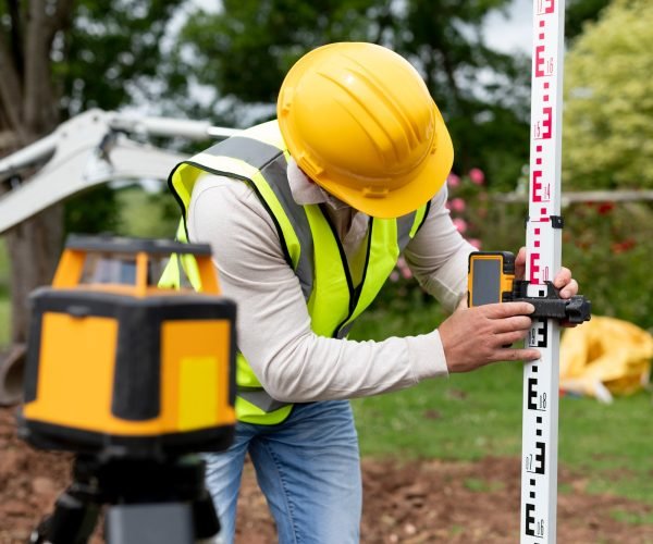 Contractor land surveying the backyard